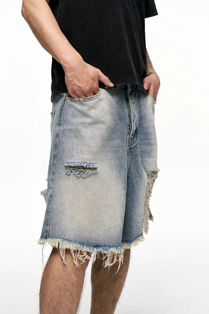 Men's light blue baggy denim shorts on a neutral background, showing wide leg and mid waist.