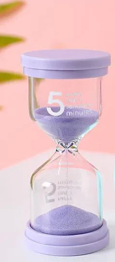 Handmade glass sand timer hourglass in blue colour showing sand flow for timing.