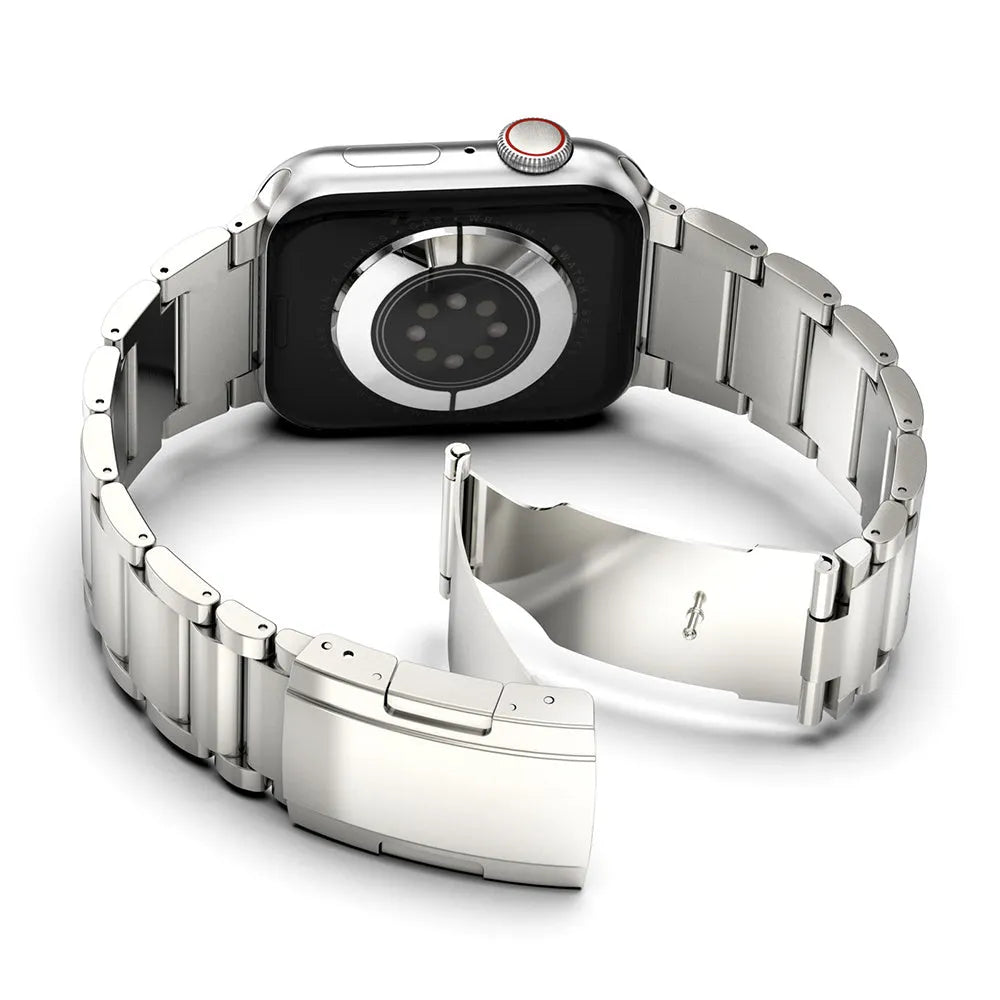 Black titanium metal Apple Watch band with a folding buckle on a table