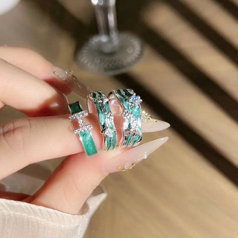 Mint green and copper asterism ring with asymmetric folding design on a hand.