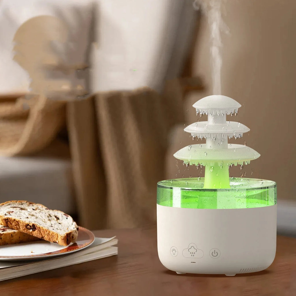 White cloud-shaped USB humidifier and essential oil diffuser with colourful mood lights on a wooden table.