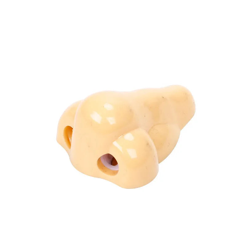 Flesh colour geometric plastic pencil sharpener with large nostril on a white background.