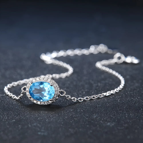 925 sterling silver four-piece jewellery set with blue topaz gems showing geometric-designed earrings, ring, pendant, and necklace