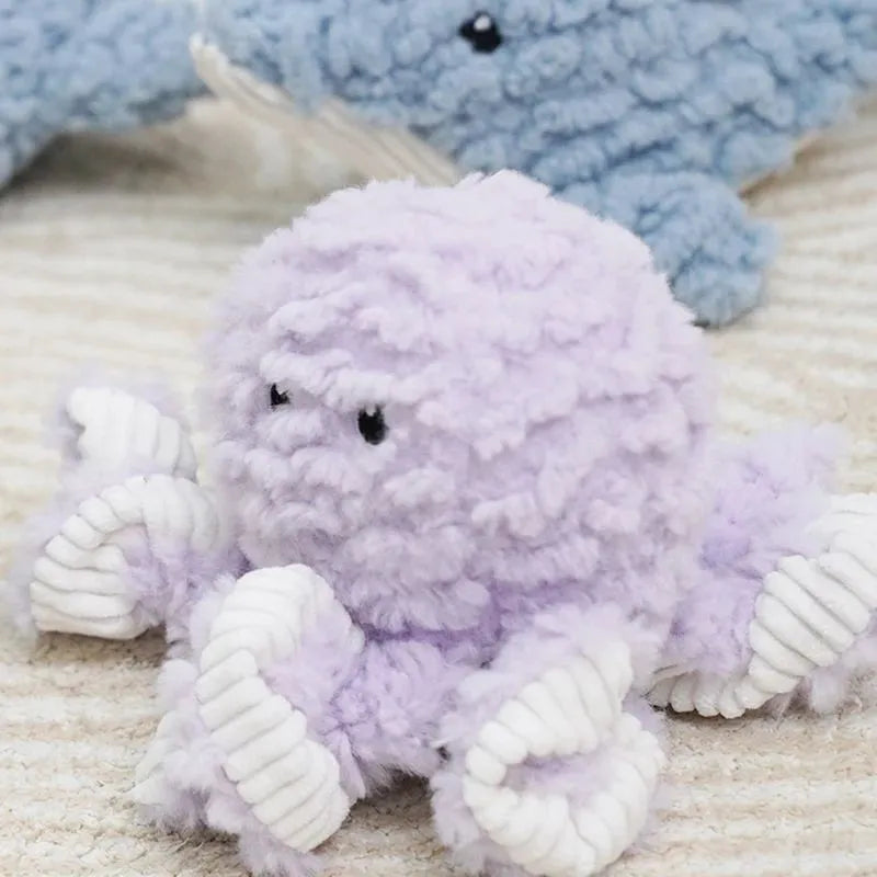 Plush corduroy caterpillar fabric dog toy in shark shape with squeaker on white background