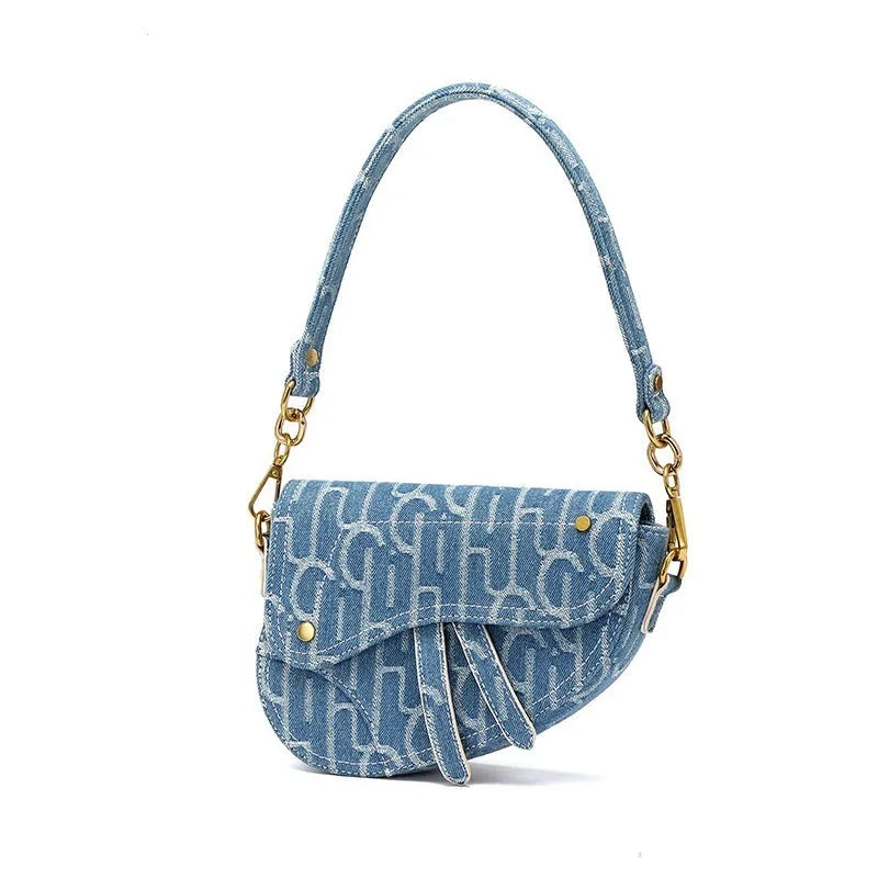 Women's vintage denim saddle bag in blue with cross-body strap and zip pocket interior