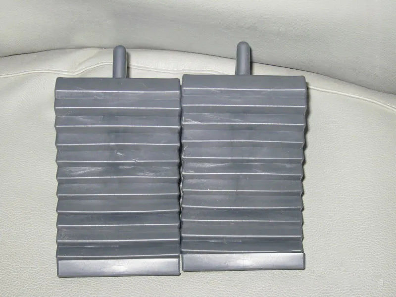 A pair of black triangular car wheel chocks for anti-slip parking safety.