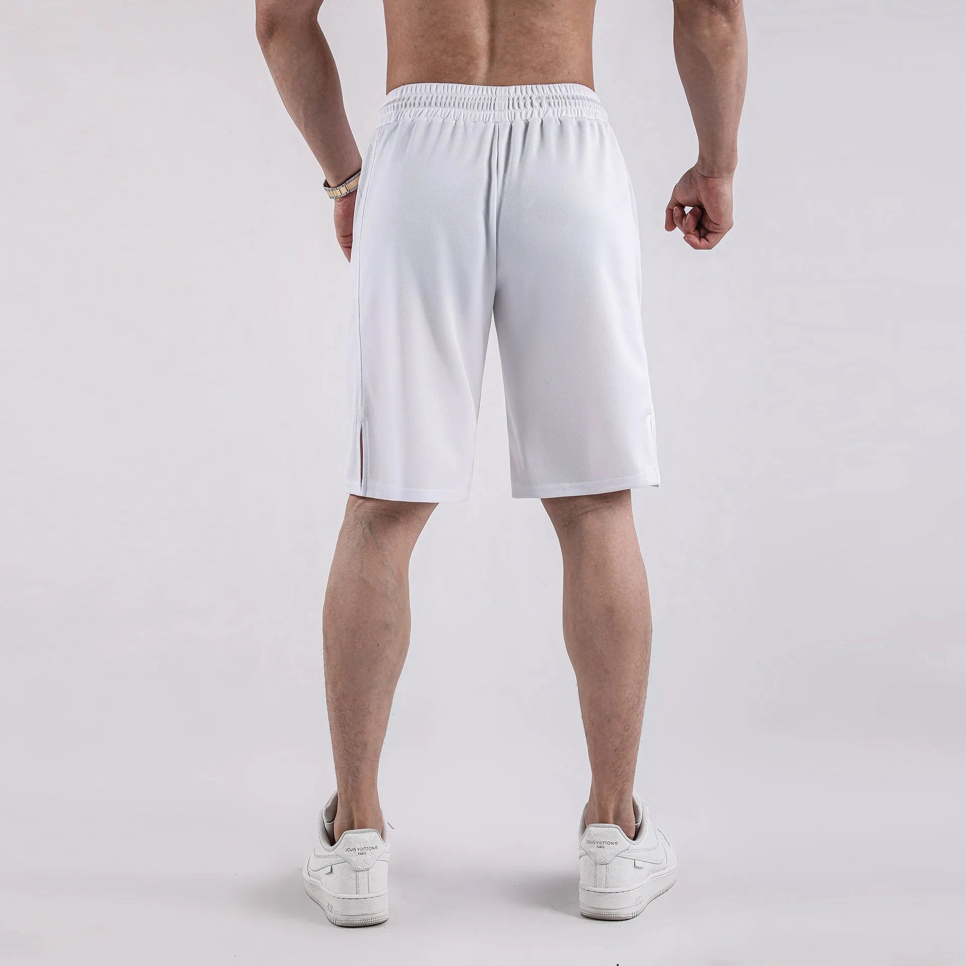 Man wearing loose black quick-dry polyester fitness shorts with an elastic waistband.