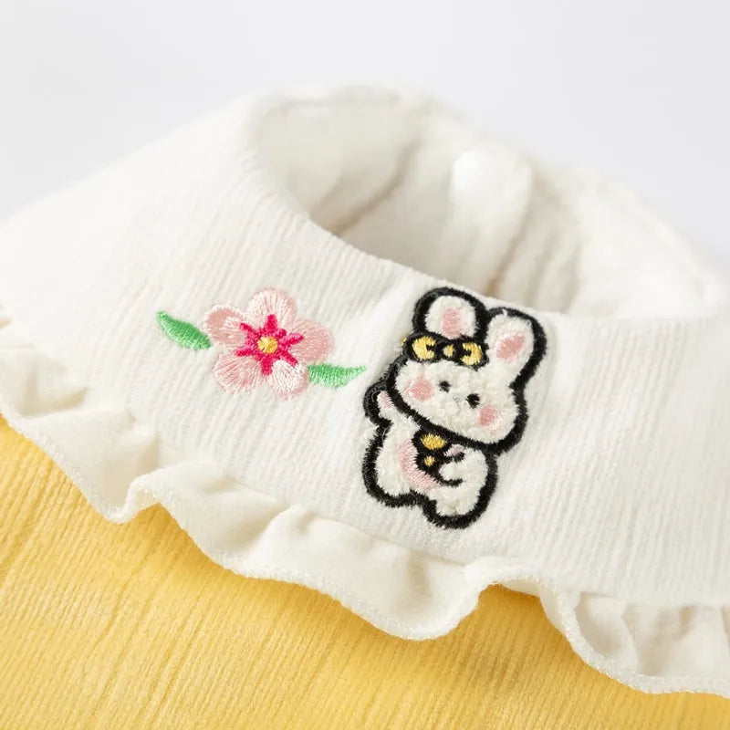Bunny embroidered pet coat with ruffled white collar and fluffy pom-pom tail in lavender colour on a small dog