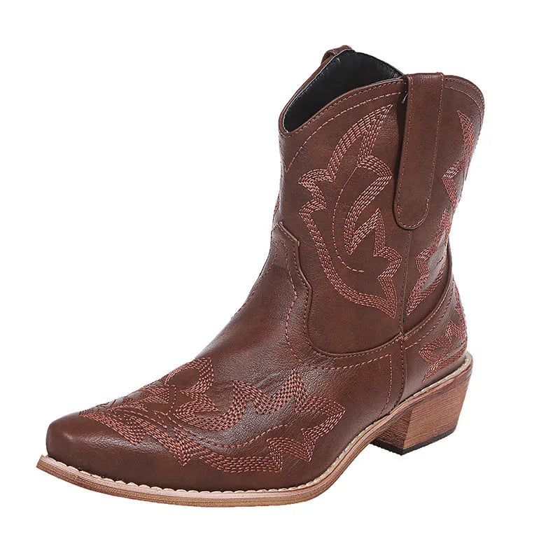 Blue women's cowboy boots with embroidery and a low wedge heel on a wooden floor.