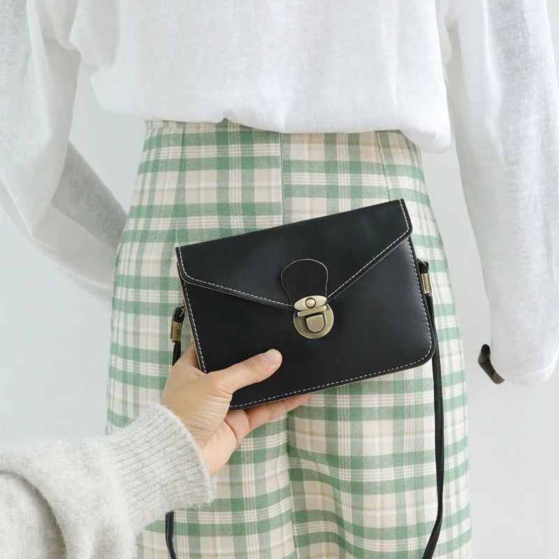 Soft surface PU messenger bag in wine red with a flap closure and metal lock detail.