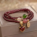 Purplish red garnet fox charm on an adjustable rope bracelet for women.
