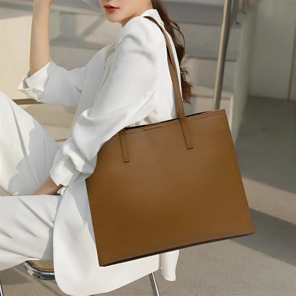 Brown genuine leather one shoulder handbag showing horizontal square shape and single strap.