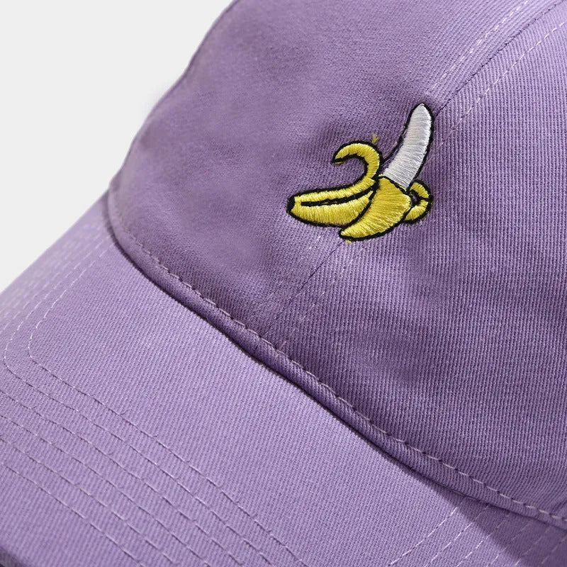 Adjustable banana-embroidered baseball cap in soft polyester fabric, shown in multiple colours.