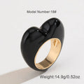 Heart-shaped zinc alloy ring with colourful three-dimensional enamel details on a neutral background.