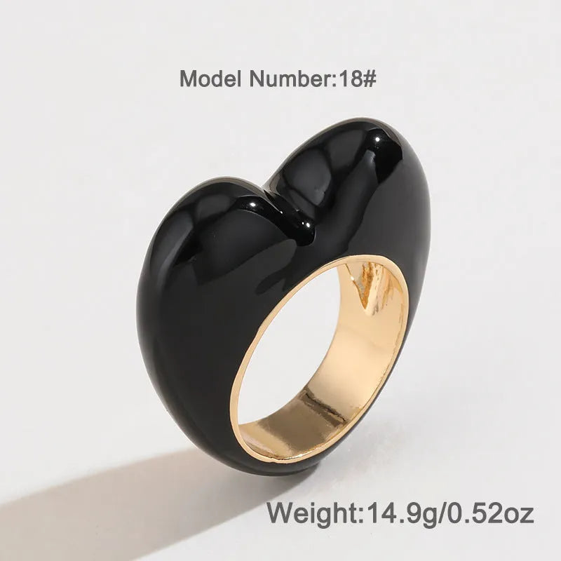Heart-shaped zinc alloy ring with colourful three-dimensional enamel details on a neutral background.