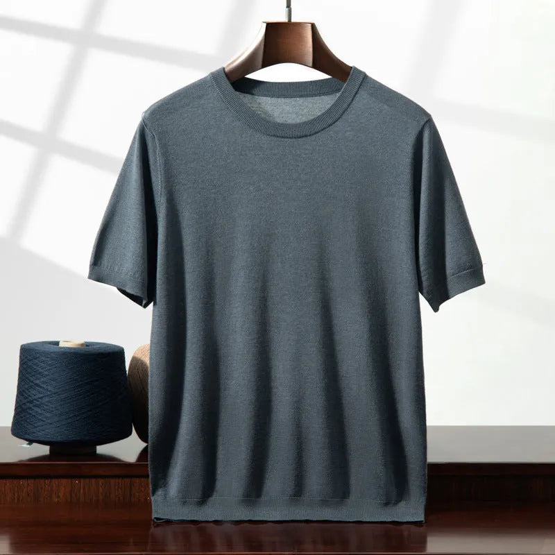 Man wearing a loose thin knitted short sleeve shirt in a casual setting