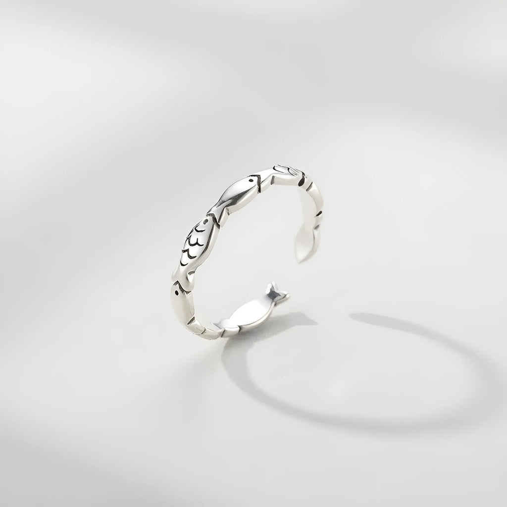 Women's sterling silver adjustable fish ring with carp motif on finger.