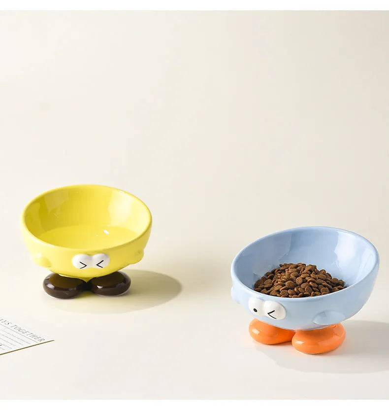 Blue ceramic oblique pet bowl with tall sides and a cute expression print for cervical spine support.