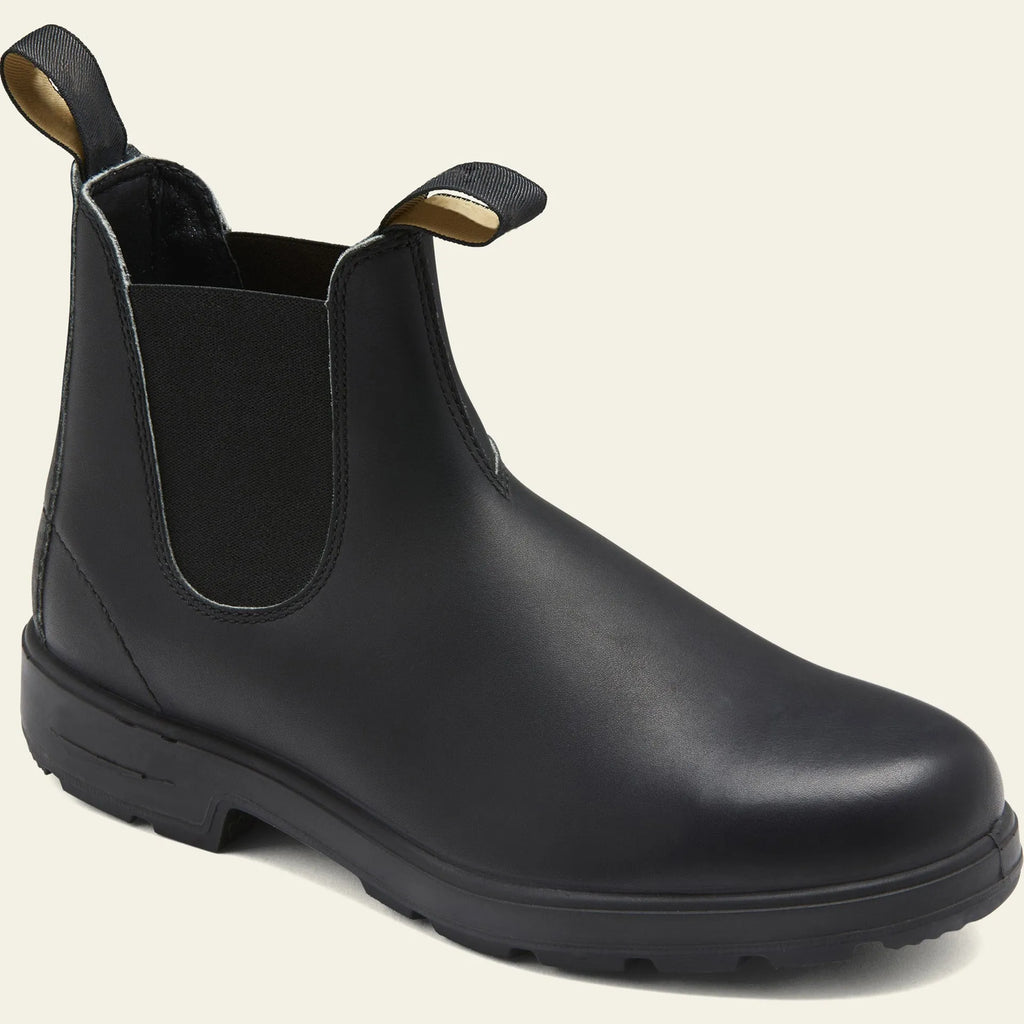 Vintage brown unisex Chelsea boots with round toe and low horseshoe heel on a wooden floor.