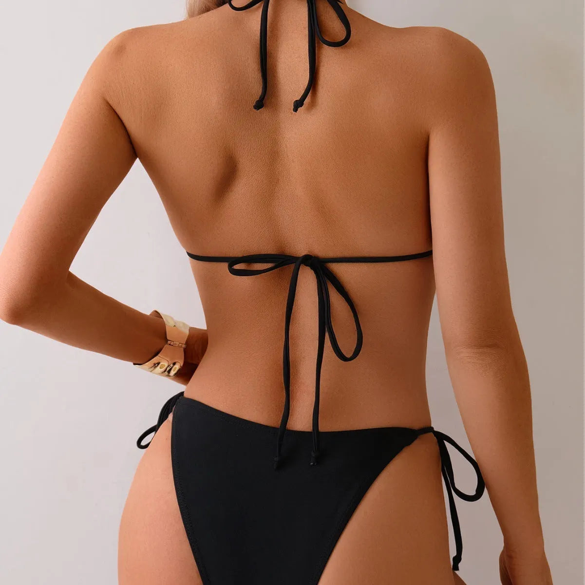 Black women's bikini swimsuit with a metal bead creating a split design on the front.