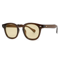 Simple round rim plastic sunglasses on a table showing bright black frame with blue lens.