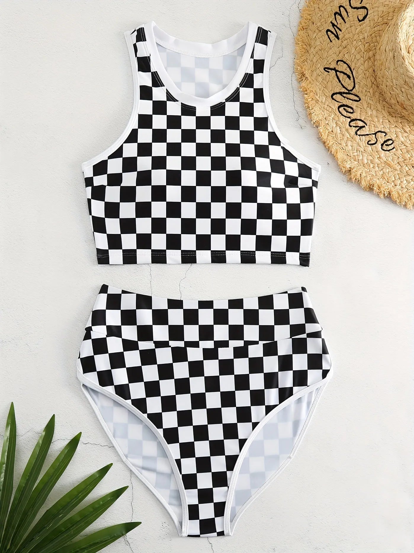 Women's backless racing one-piece swimsuit with suspenders in a black and white chessboard pattern.