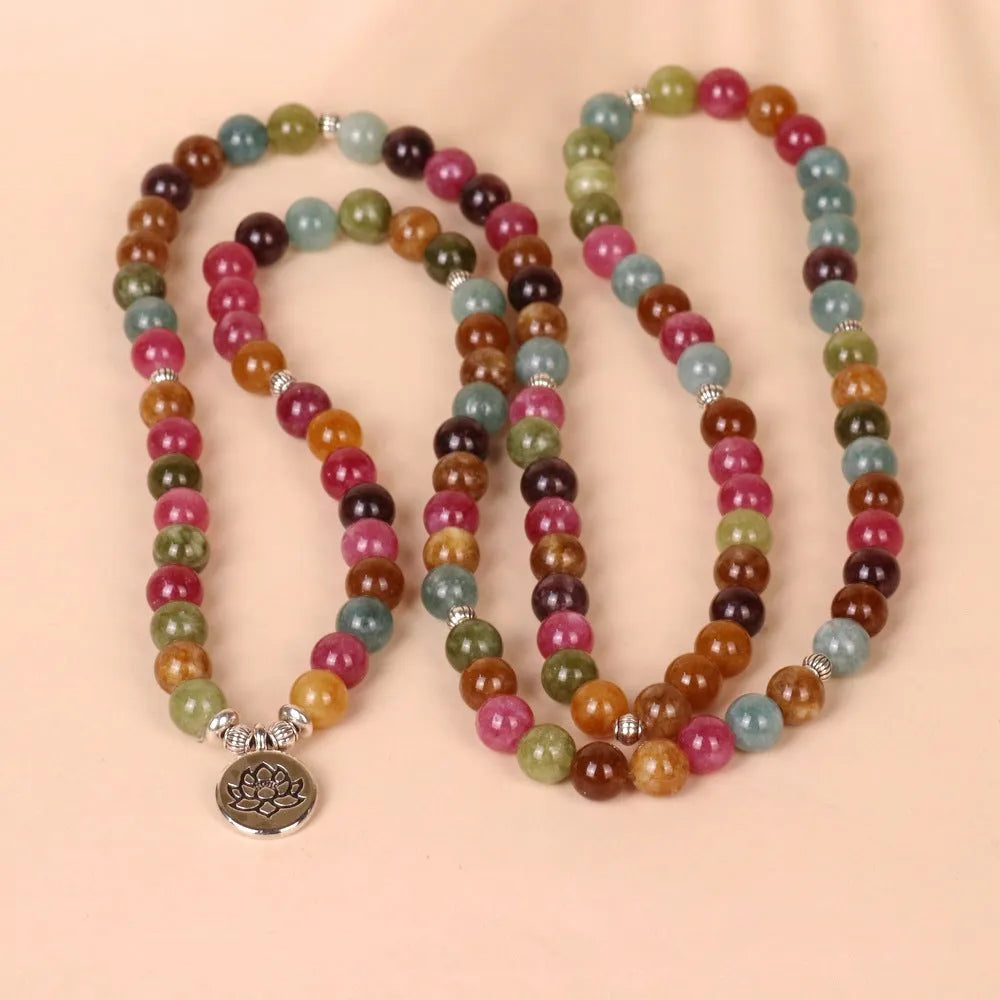 Close-up of a Tourmaline-coloured alloy bracelet with 108 beads and a central hanging lotus decoration.