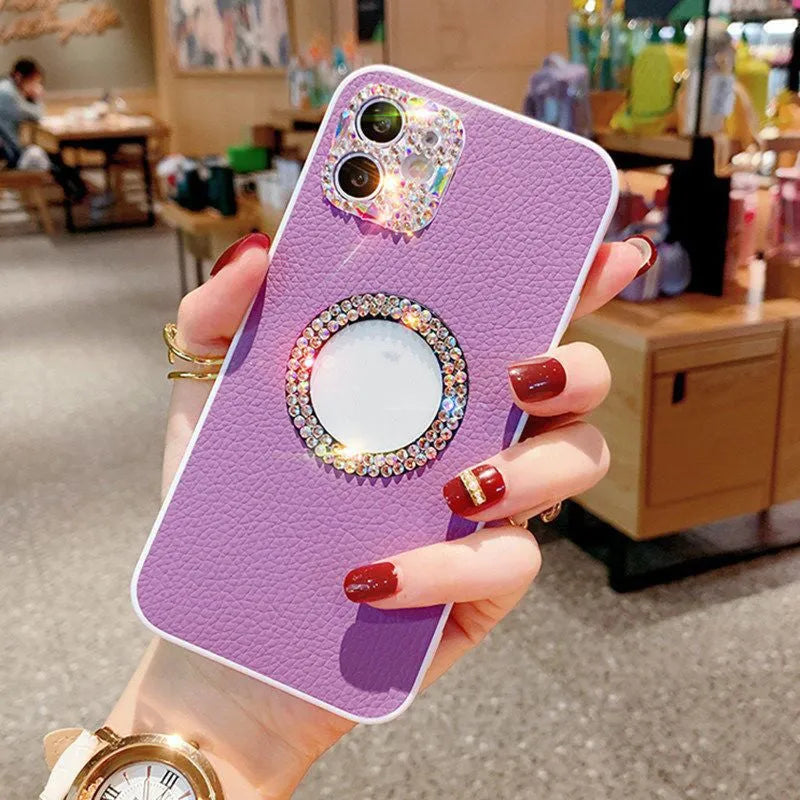 Luxury rhinestone TPU back cover phone case for iPhone in pink, purple, and white on a surface