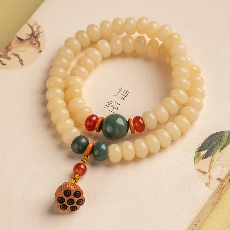Cream topaz wooden bodhi root bracelet with flat round beads on a wrist.