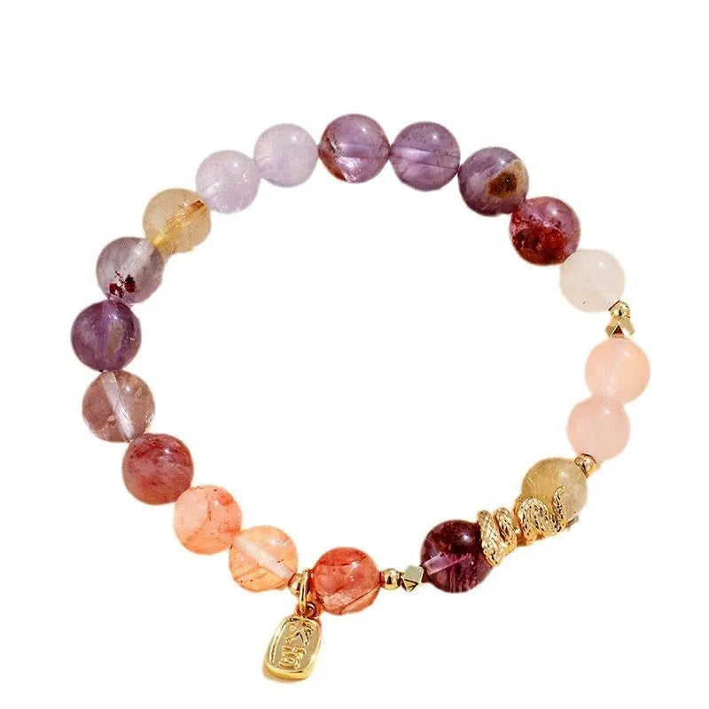 Handmade women's crystal string bracelet with lucky snake charm and coloured beads on wrist.