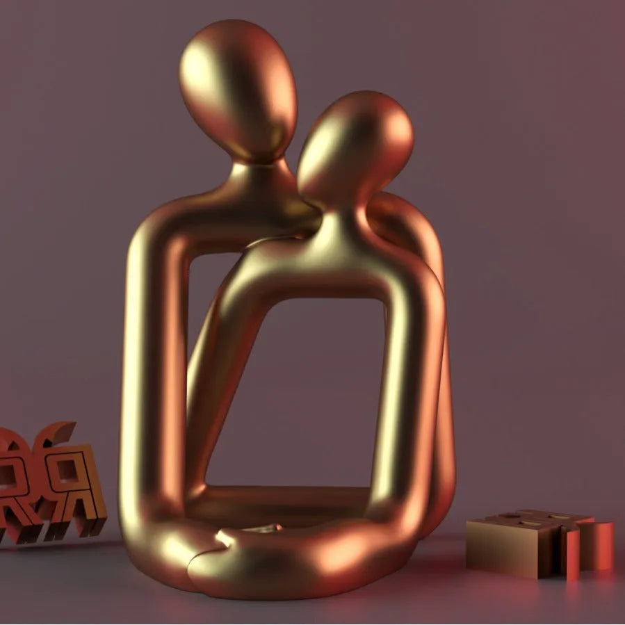 Modern minimalist loving couple resin statue in gold or milky white on a wooden surface.