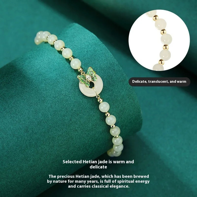 Cyan Hetian jade bracelet with a detailed sterling silver butterfly and gemstone ornament.