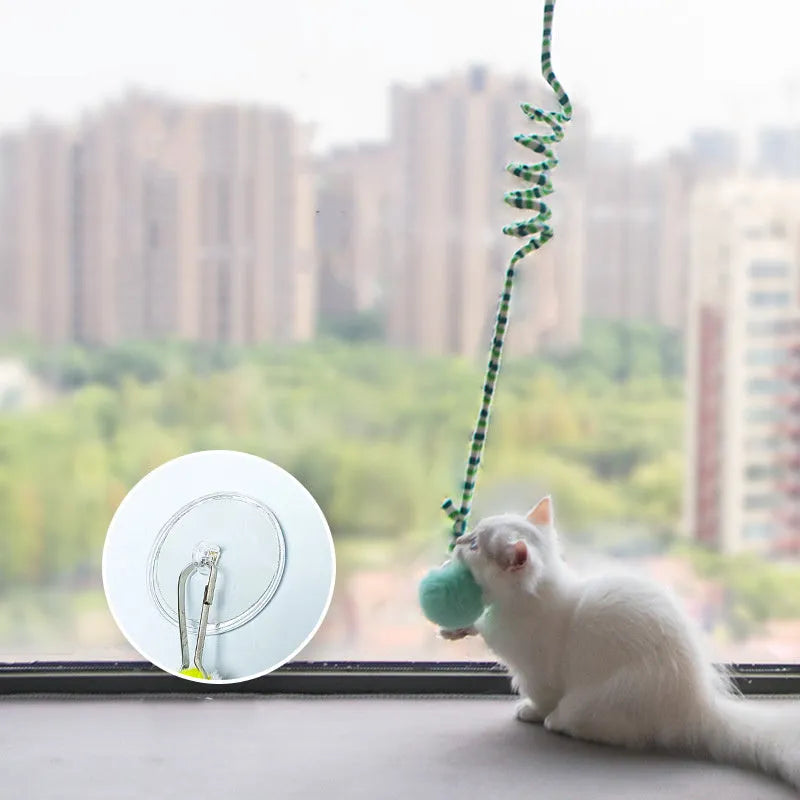 Inflatable ball cat toy with bell stick on a spring, hanging from a door via a suction cup.