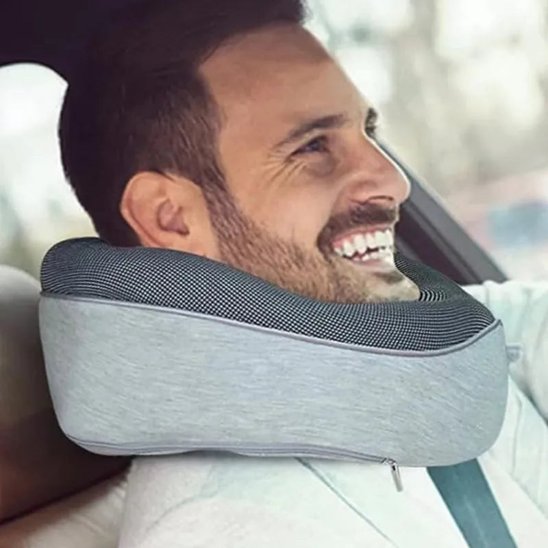 U-shaped navy blue memory foam travel neck pillow rolled up next to a mobile phone showing compact size