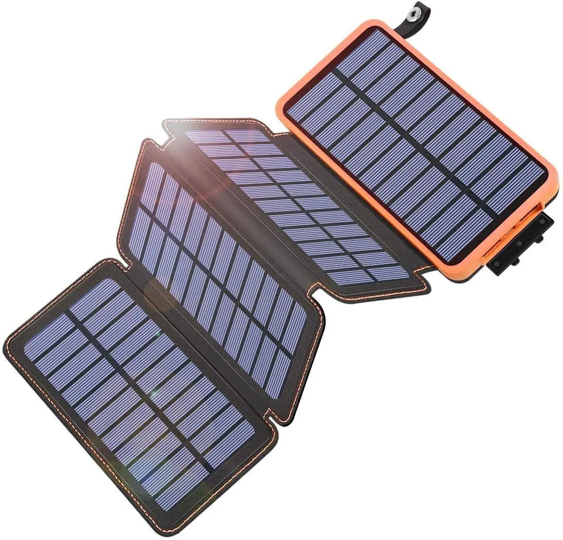 Black outdoor solar power bank with a solar panel and a built-in LED light displayed on a rock.
