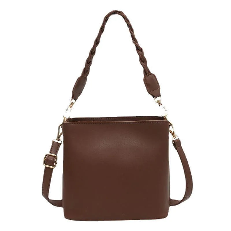 Khaki coloured PU leather one-shoulder crossbody bucket bag with woven detail on the front.