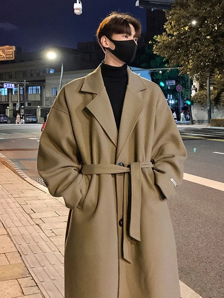 Men's British style mid-long wool coat in khaki with side seam pockets on a hanger