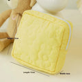 Quilted silk cosmetic bag in candy colours showing pink, yellow, blue, white, and green options