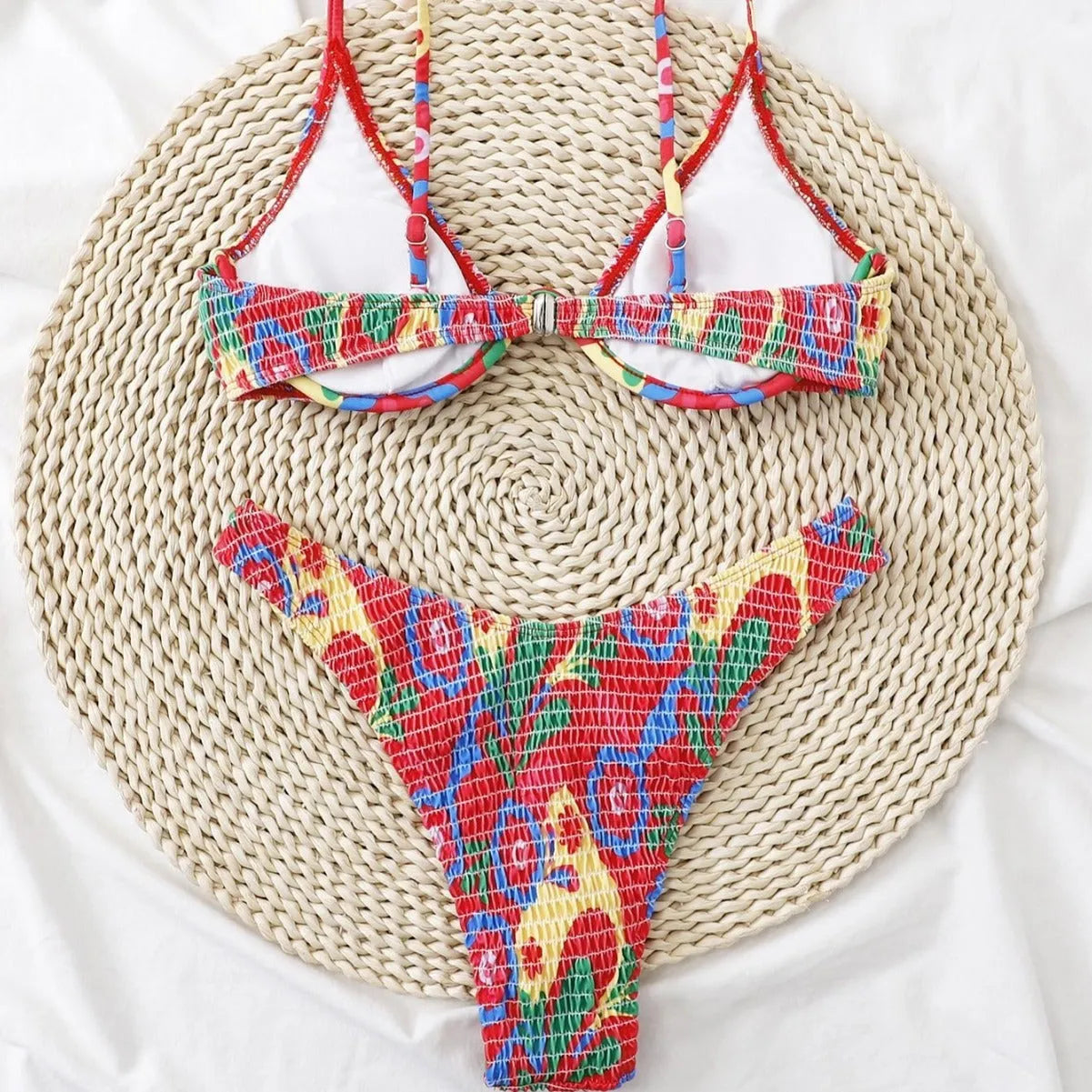 Red floral patterned women's underwire triangle bikini top and briefs set on a white background.