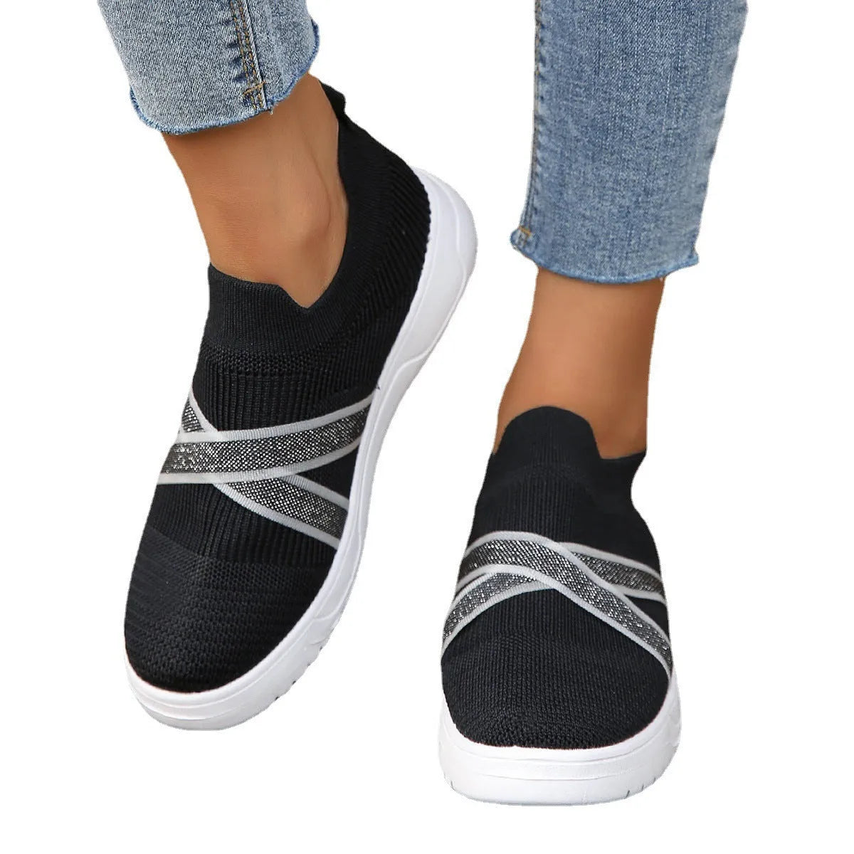 Black women's flat shoes with flyknit mesh upper, round toe, tassel detail, and flat rubber sole.