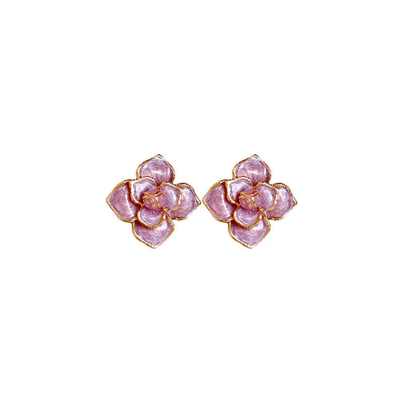 Close-up of a pair of gold plated flower stud earrings with a purple oil-spot glaze finish.