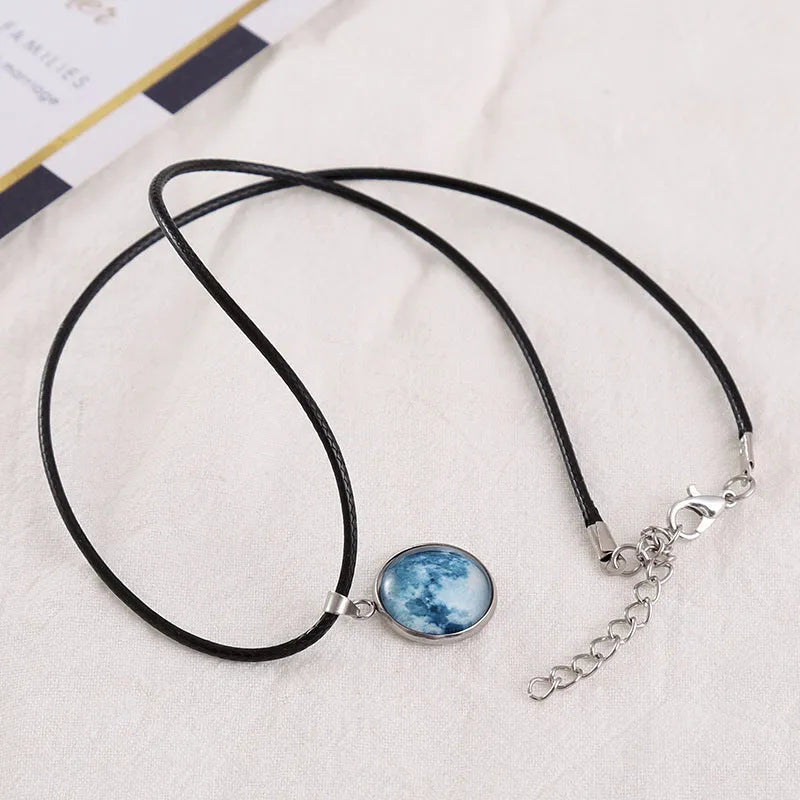 Luminous moon and constellation glass pendant on a silver alloy necklace chain with an extension piece.