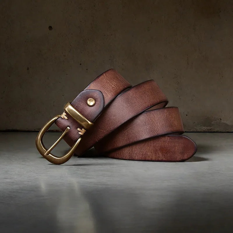 Men's black genuine cattlehide leather belt with a copper pin buckle on a jeans background