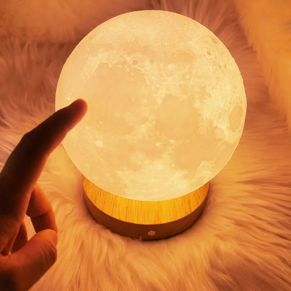 Rotating moon night light on wooden base showing three colour settings
