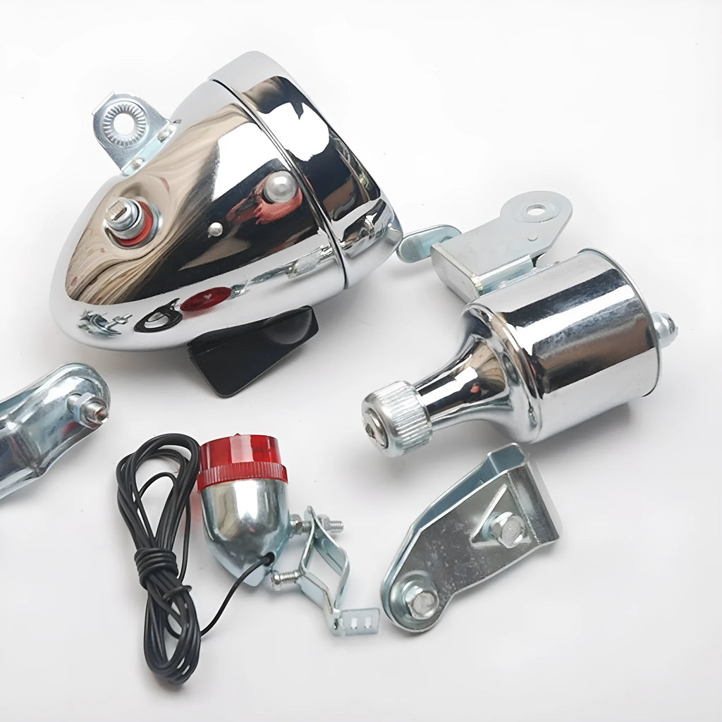 Silver bicycle dynamo generator light kit mounted on a bicycle frame with headlight and taillight.