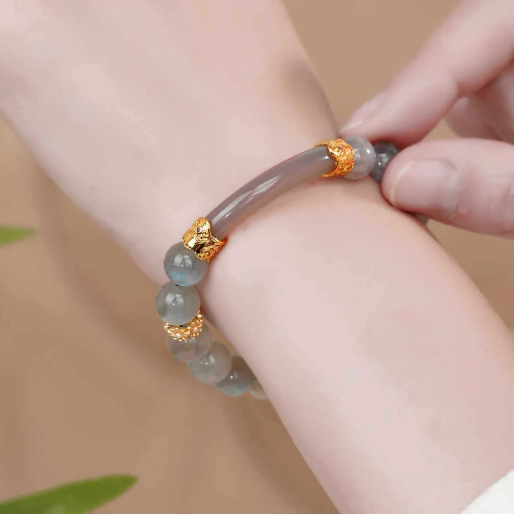 Grey moonstone agate half-wrap bracelet with 8mm round beads on a woman's wrist.