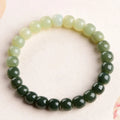 Natural Hetian jade bracelet with gradient clear water colours on a wrist, showing polished beads.