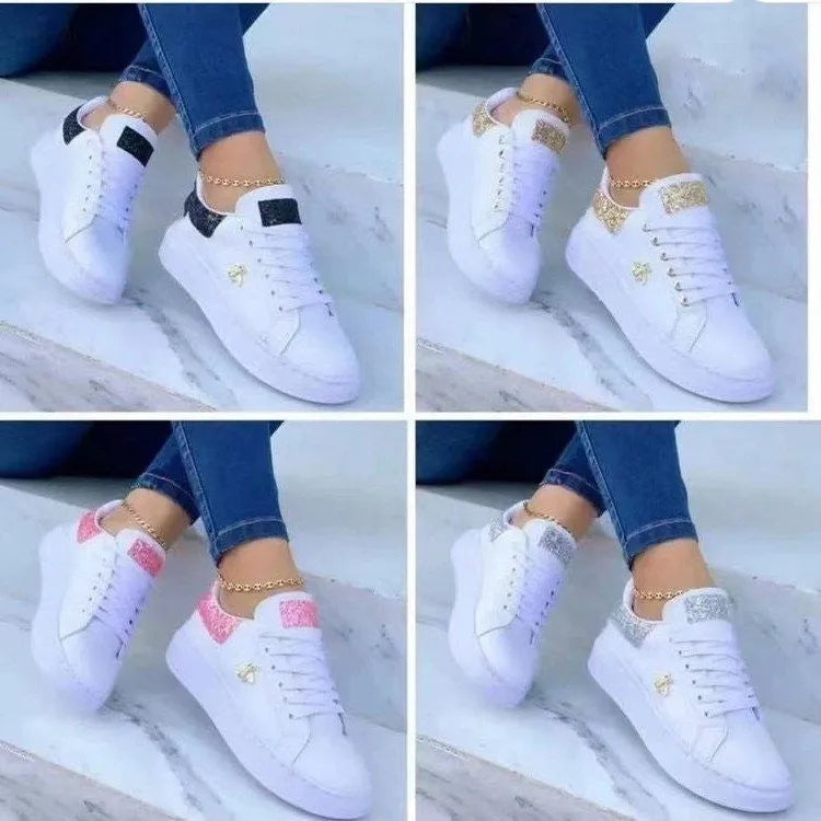 White low-top platform sneakers with lace-up closure and rubber sole on a light background