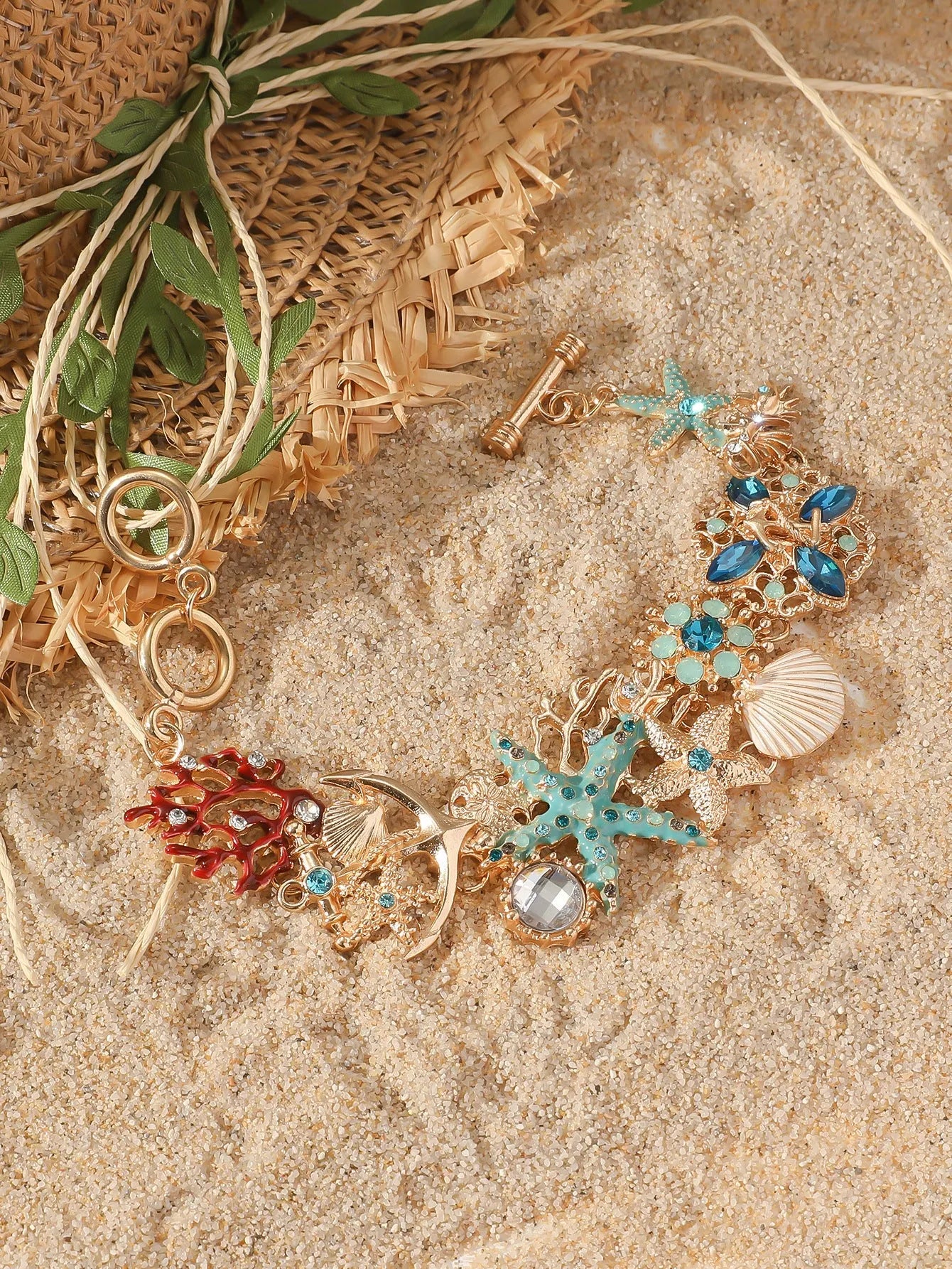 Alloy rhinestone bracelet with boat anchor, marine shell, and starfish charms in blue, red, or turquoise.