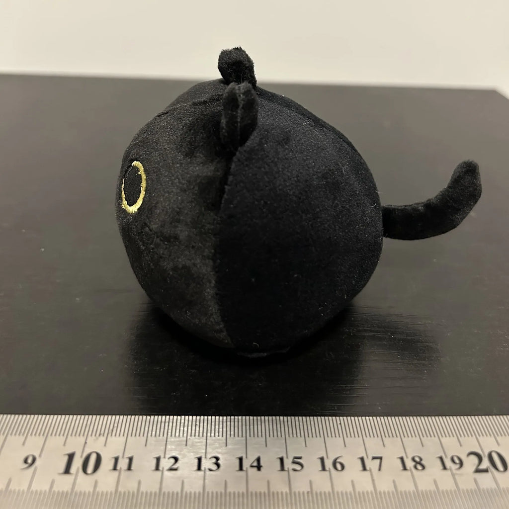Fluffy black cat plush toy stuffed animal pillow cushion on a neutral background